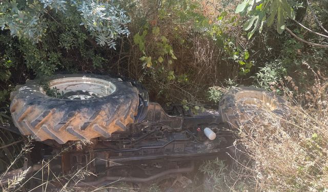 Devrilen traktörün altında kalan sürücüyü itfaiyeciler kurtardı